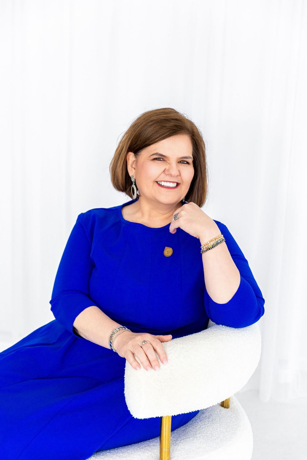 Portrait of Vicki Christensen seated in a bright studio