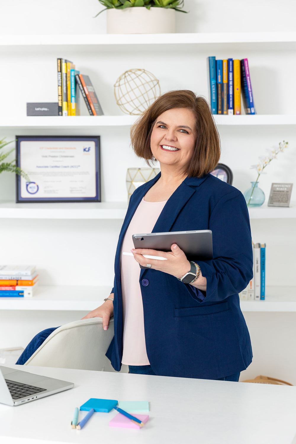 Vicki standing in her office holding a tablet